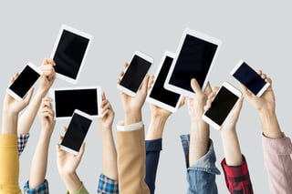 People holding a variety of mobile devices aloft