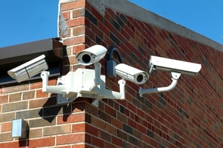 Security cameras affixed to brick wall